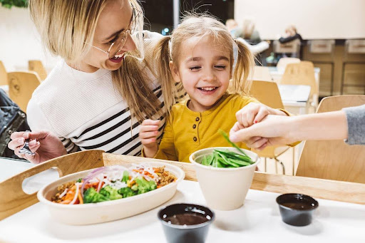 A happy family enjoying customizable bowls together at Balance Pan-Asian Grille.