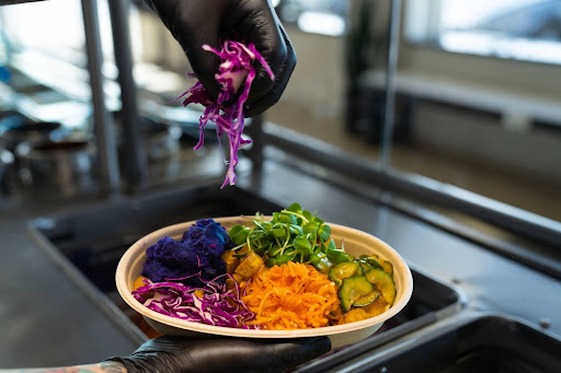 Creating a balanced bowl with fresh ingredients at Balance Grille.