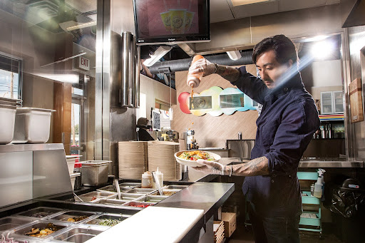Head Chef CJ at Balance Grille in Sylvania preparing a custom bowl with fresh ingredients.