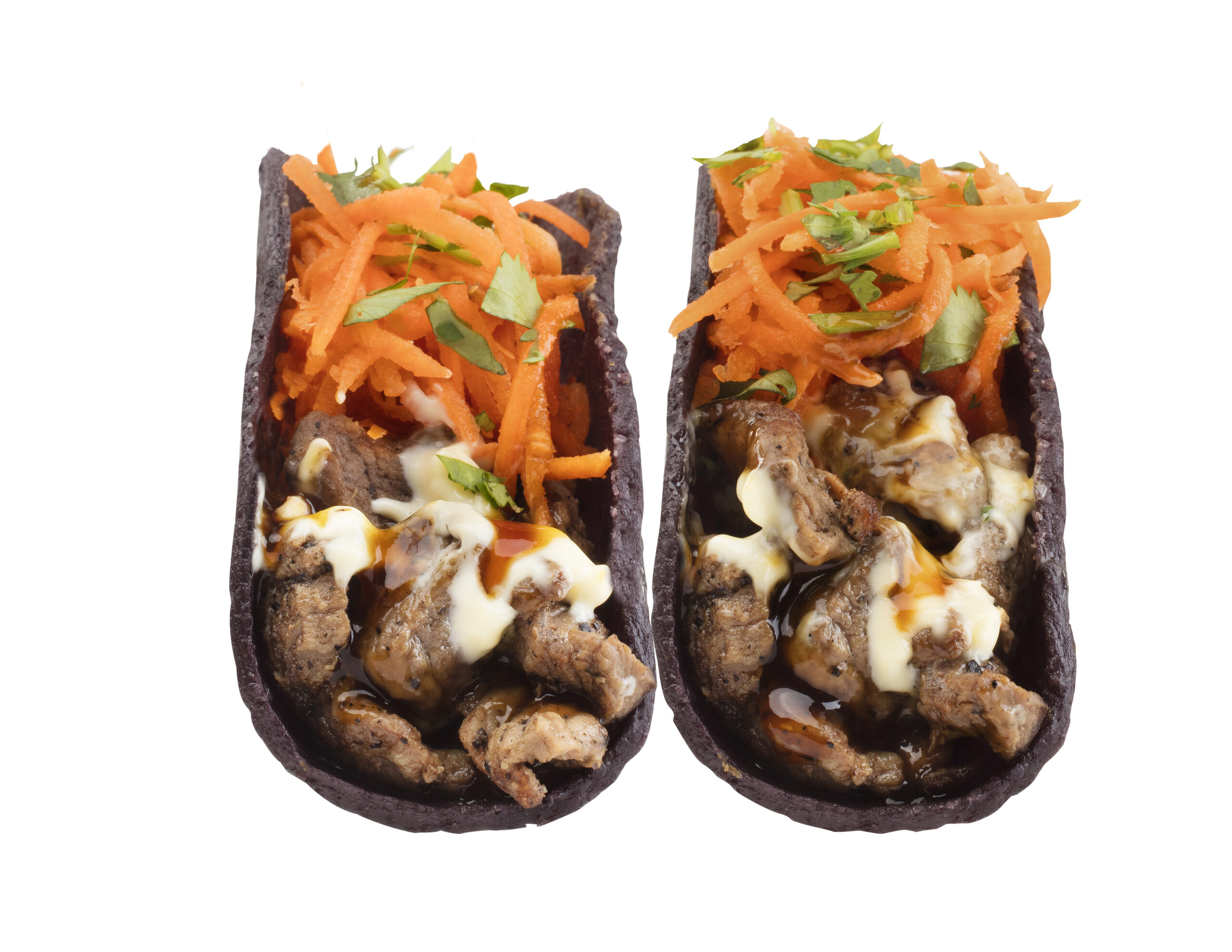 Mongo tacos at Balance Grille featuring wok fired beef, shredded carrots, Japanese mayo, and fresh cilantro in black corn tortillas.