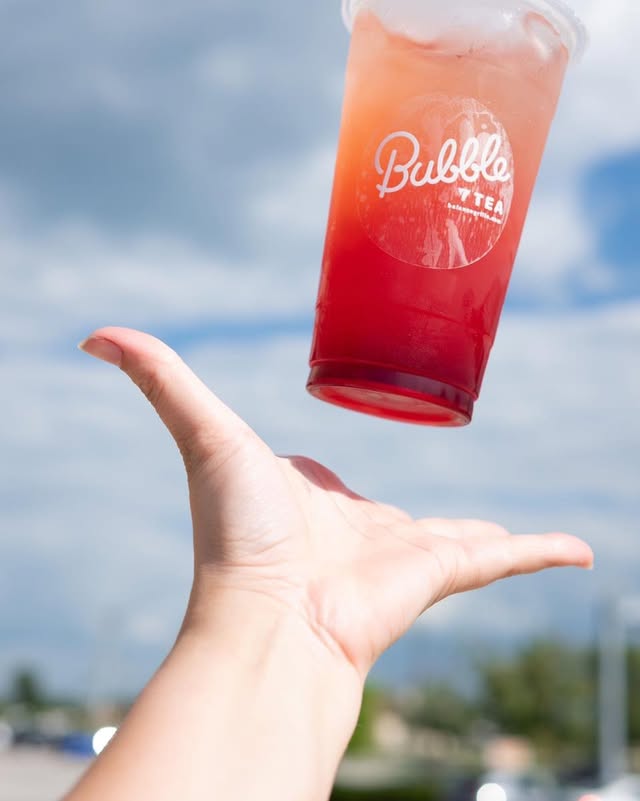 Person holding a freshly brewed bubble tea from Balance Grille.